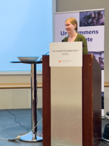 Bildet viser Solveig-Marie Oma på talerstolen på Ungdommens kirkemøte 2022