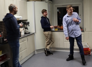 Bildet viser tre personer på kjøkkenet i et forsamlingshus, deriblant Asbjørn.