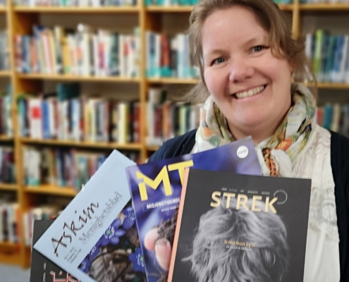 Bibliotekar Heidi Vestbye med magasiner i hånden.