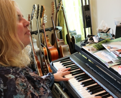 Heidi sitter og spiller på pianoet.